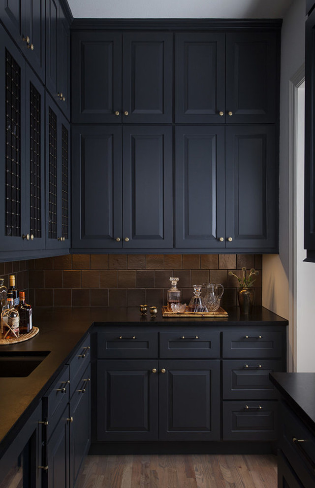 Kitchen pantry - mid-sized transitional galley light wood floor and brown floor kitchen pantry idea in Austin with an undermount sink, raised-panel cabinets, black cabinets, soapstone countertops, black backsplash, porcelain backsplash, no island and black countertops