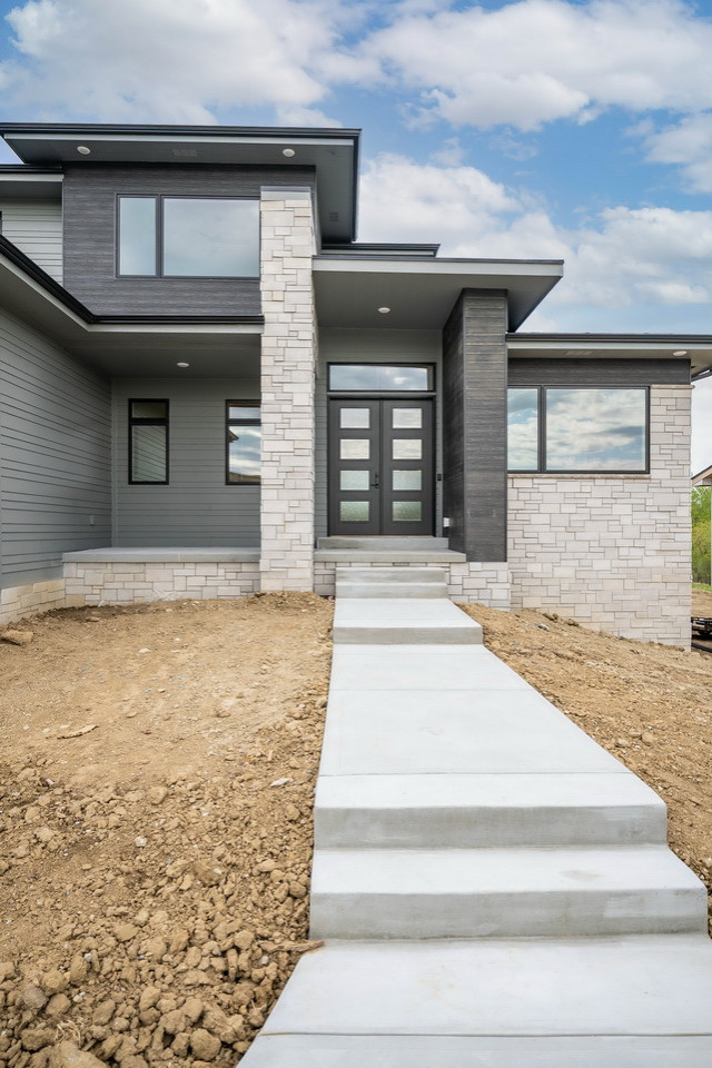 Modernes Einfamilienhaus mit grauer Fassadenfarbe und schwarzem Dach in Omaha