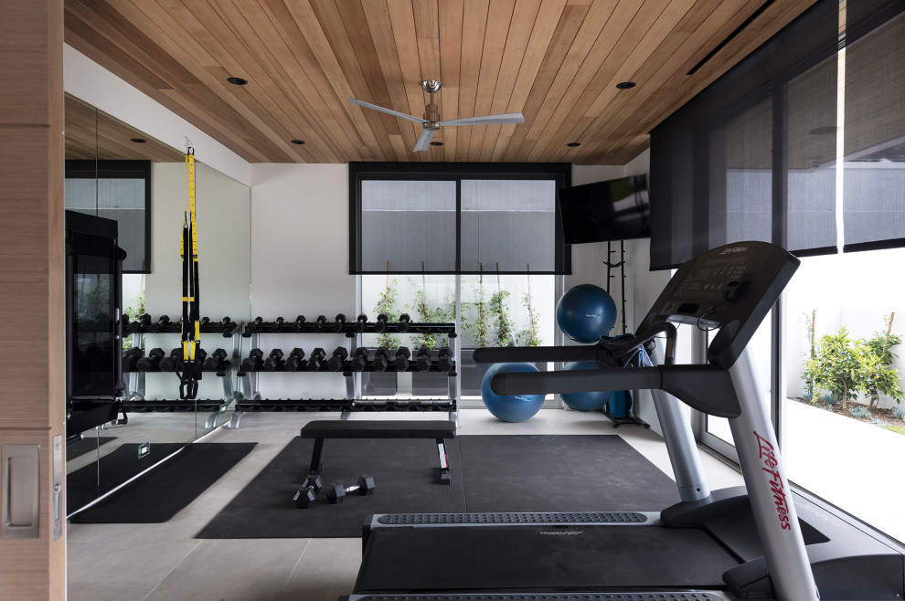 Multifunktionaler, Mittelgroßer Moderner Fitnessraum mit weißer Wandfarbe, Porzellan-Bodenfliesen, beigem Boden und Holzdecke in Orange County