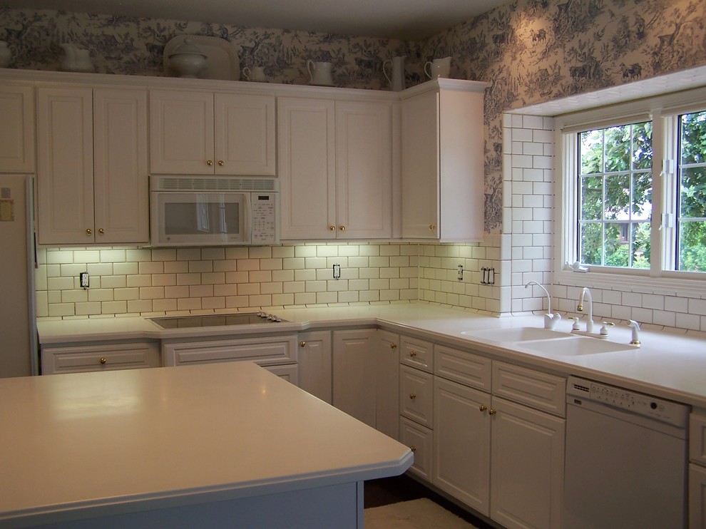 Eat-in kitchen - traditional l-shaped eat-in kitchen idea with solid surface countertops and ceramic backsplash