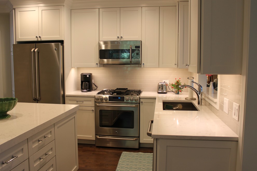 Enclosed kitchen - mid-sized transitional l-shaped dark wood floor and brown floor enclosed kitchen idea in Chicago with an undermount sink, recessed-panel cabinets, white cabinets, quartzite countertops, white backsplash, subway tile backsplash, stainless steel appliances and an island