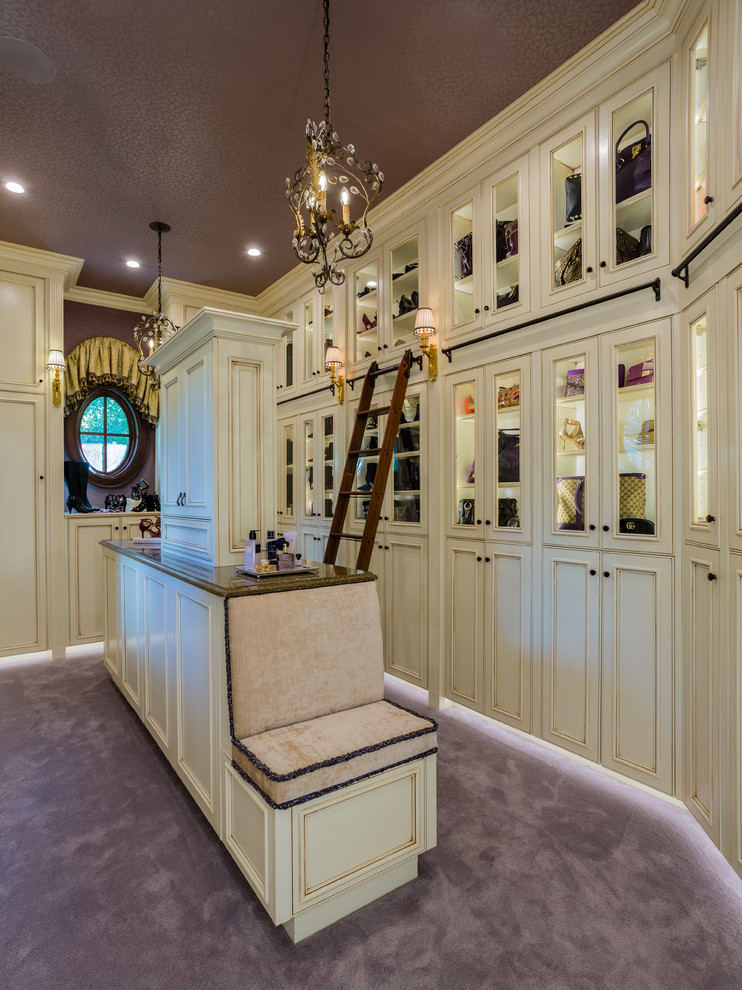 Photo of a mediterranean women's dressing room in Other with beaded inset cabinets, carpet, purple floor and beige cabinets.