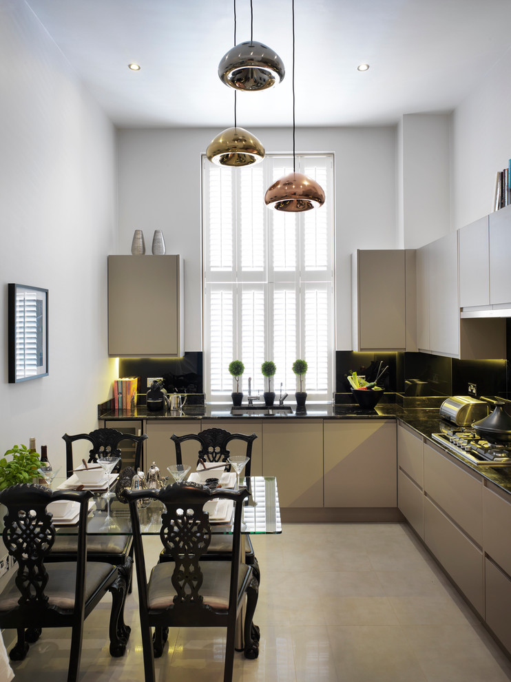 Photo of a contemporary eat-in kitchen in London with an undermount sink, flat-panel cabinets, beige cabinets, black splashback, glass sheet splashback and panelled appliances.