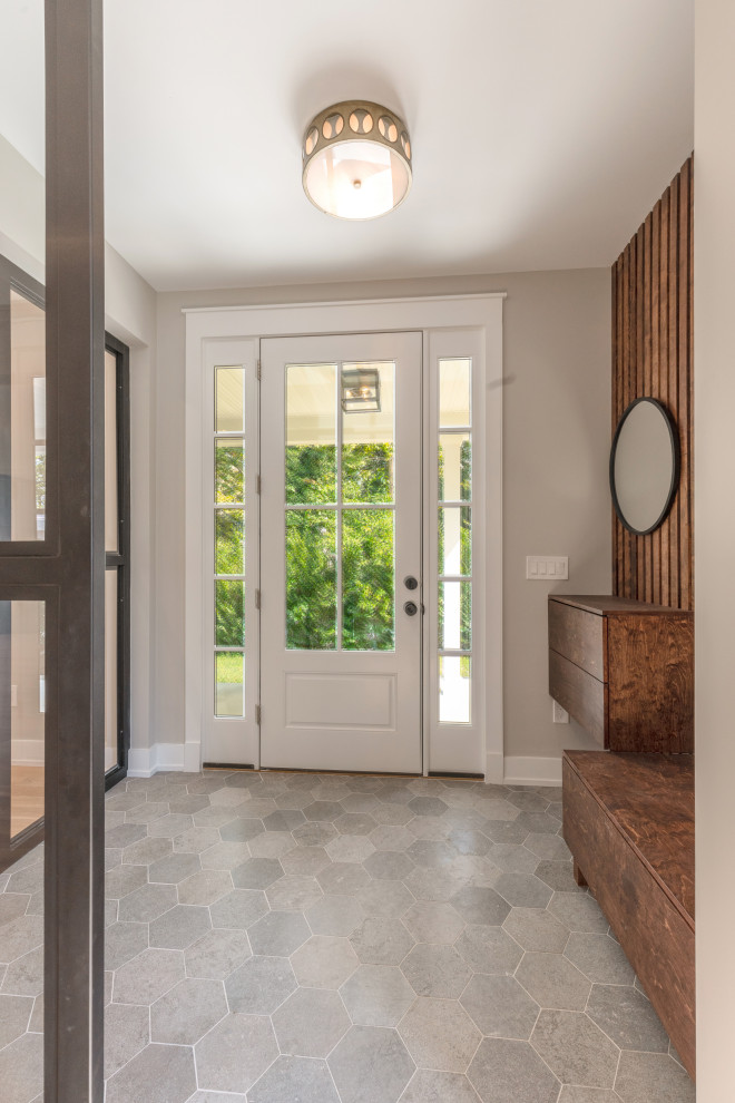 Ejemplo de distribuidor de estilo de casa de campo con paredes beige, suelo de baldosas de cerámica, puerta simple, puerta negra, suelo gris y madera