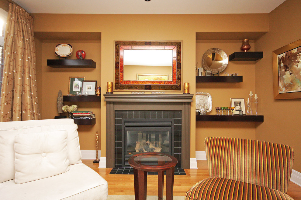 This is an example of a mid-sized contemporary living room in Toronto with orange walls, light hardwood floors, a standard fireplace and a tile fireplace surround.