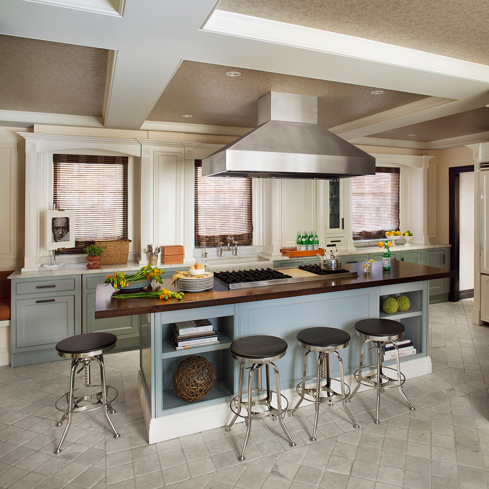 Transitional kitchen in New York with a farmhouse sink, recessed-panel cabinets, blue cabinets and wood benchtops.