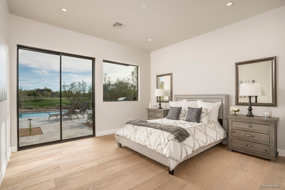 This is an example of a mid-sized contemporary guest bedroom in Phoenix with beige walls, light hardwood floors and no fireplace.