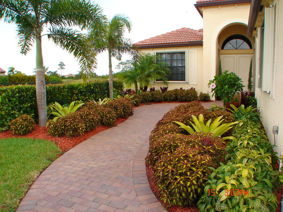 Mid-sized traditional front yard partial sun garden in Orlando with brick pavers.