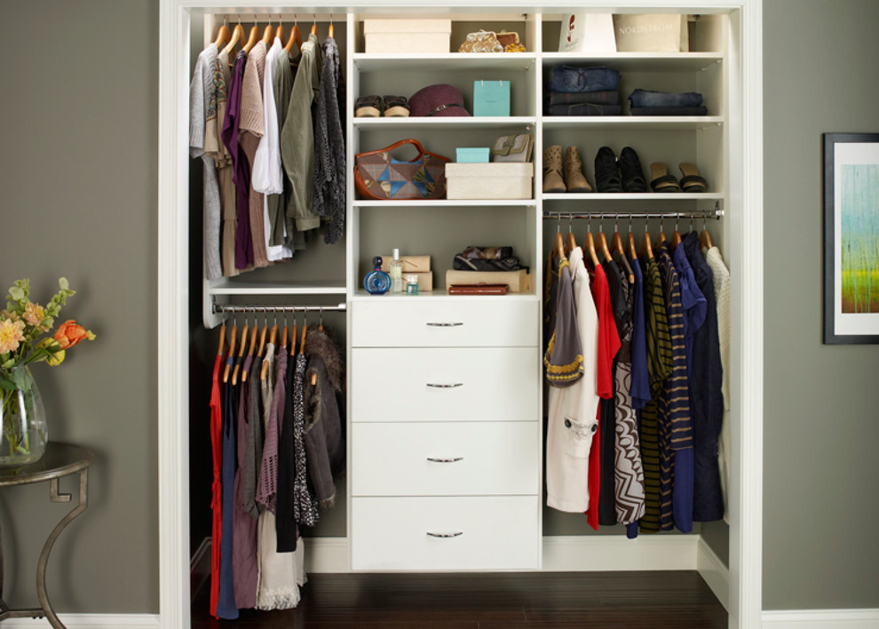 This is an example of a small contemporary women's built-in wardrobe in Boston with flat-panel cabinets, white cabinets and dark hardwood floors.