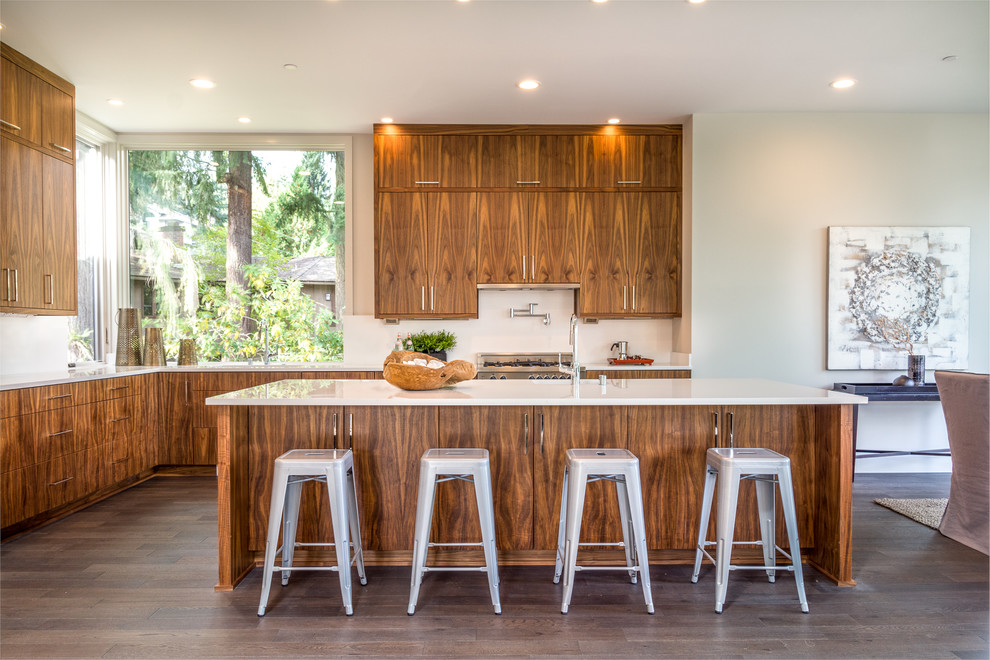 Photo of a contemporary l-shaped eat-in kitchen in Seattle with flat-panel cabinets, medium wood cabinets, white splashback, stainless steel appliances, dark hardwood floors, with island and brown floor.