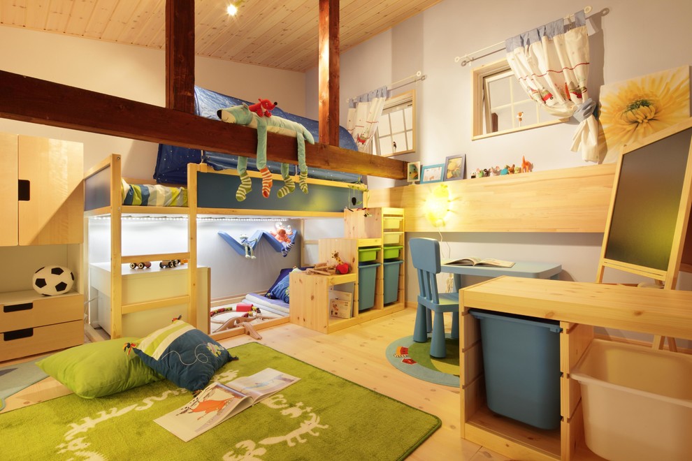 This is an example of a scandinavian kids' room for boys in Other with light hardwood floors and multi-coloured walls.