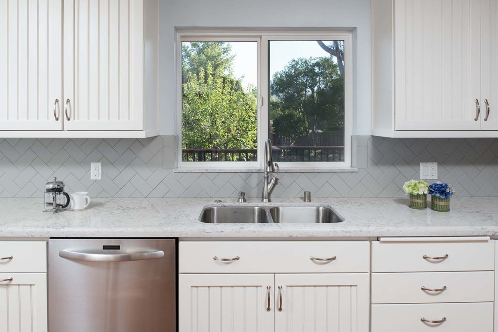Inspiration for a mid-sized transitional galley eat-in kitchen in San Diego with an undermount sink, shaker cabinets, white cabinets, quartz benchtops, grey splashback, subway tile splashback, stainless steel appliances, medium hardwood floors and a peninsula.