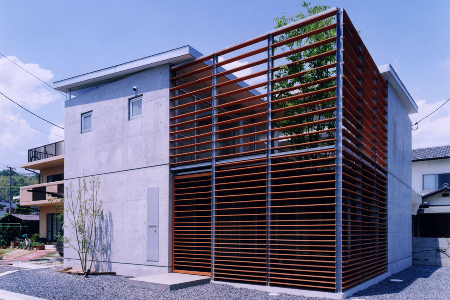 Esempio della facciata di una casa grigia moderna a due piani di medie dimensioni con rivestimento in cemento, copertura in metallo o lamiera e tetto grigio