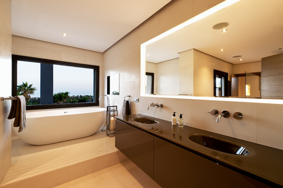 This is an example of a large contemporary master bathroom in Other with an integrated sink, flat-panel cabinets, brown cabinets, a freestanding tub, an alcove shower, beige tile, beige walls, ceramic tile, ceramic floors, solid surface benchtops and beige floor.