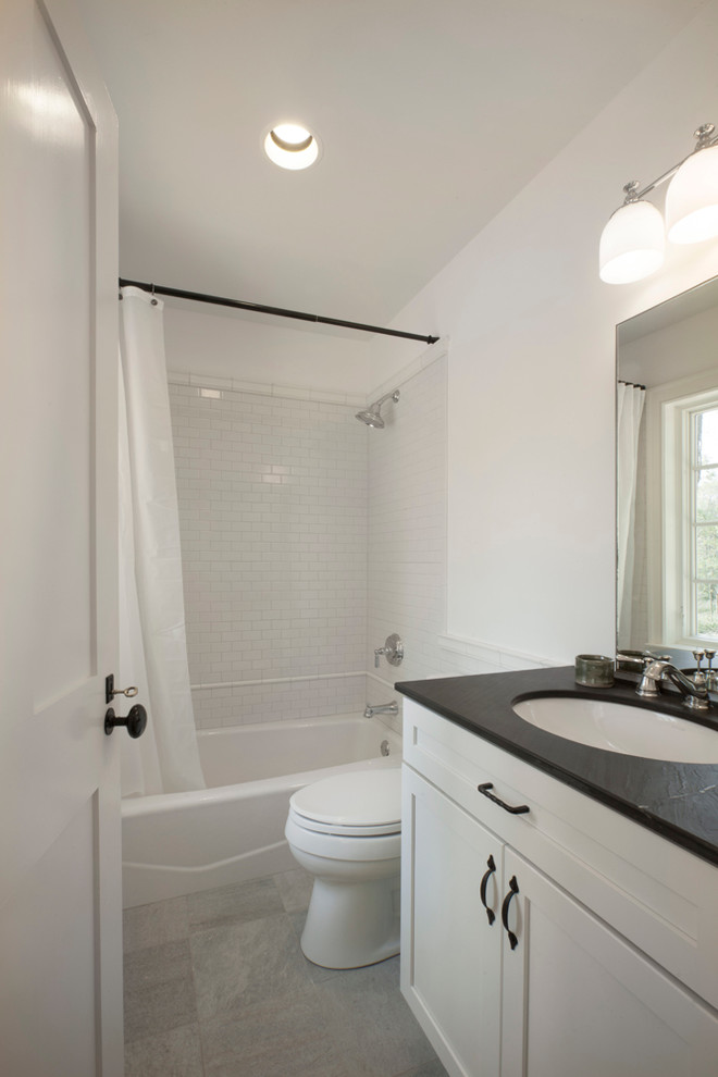 Example of a mid-sized country master white tile and subway tile porcelain tile bathroom design in Cincinnati with an undermount sink, recessed-panel cabinets, white cabinets, soapstone countertops, a two-piece toilet and white walls