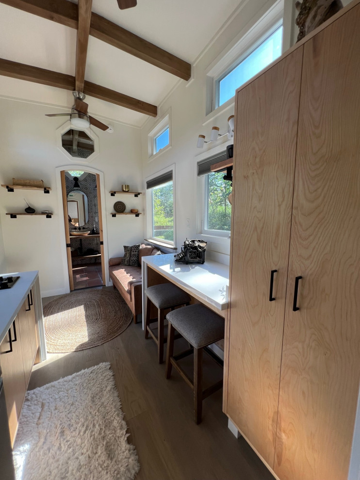 Esempio di una piccola sala da pranzo aperta verso la cucina country con pareti bianche, parquet chiaro, pavimento beige e travi a vista
