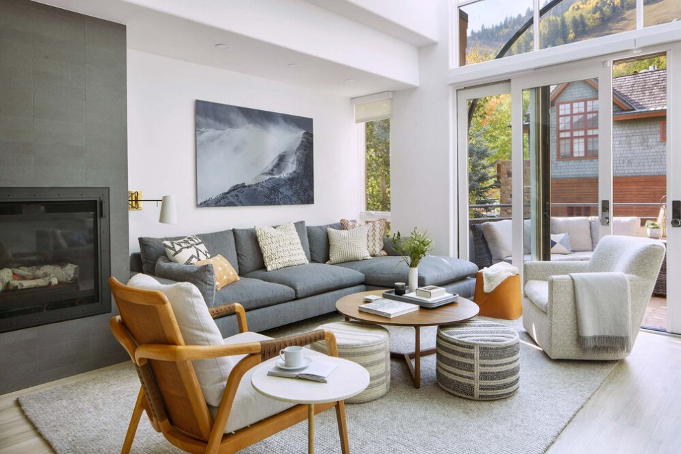 Inspiration for a mid-sized contemporary formal enclosed living room in Denver with medium hardwood floors, a standard fireplace, a metal fireplace surround and no tv.