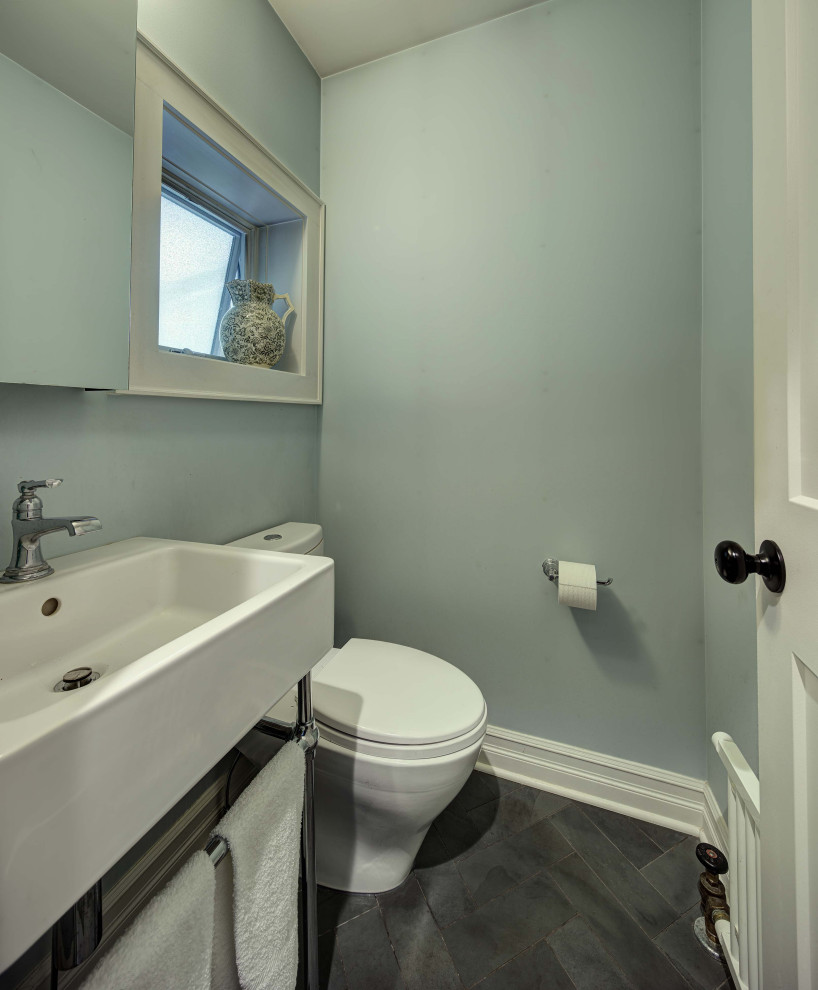Photo of a small country powder room in New York with a two-piece toilet, blue walls, slate floors, an integrated sink, grey floor and a freestanding vanity.