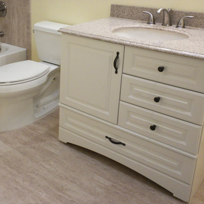 Inspiration for a small traditional 3/4 bathroom in Denver with raised-panel cabinets, white cabinets, an alcove tub, a shower/bathtub combo, a two-piece toilet, yellow walls, laminate floors, an undermount sink, granite benchtops, beige floor and a shower curtain.