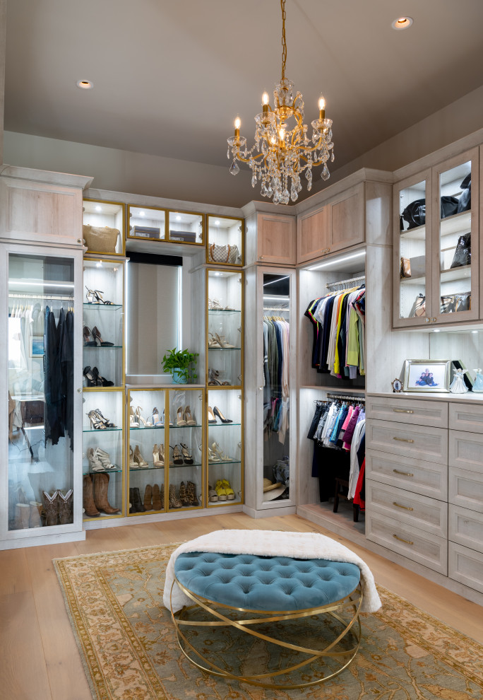 Medium sized classic walk-in wardrobe for women in Dallas with recessed-panel cabinets, light wood cabinets and light hardwood flooring.