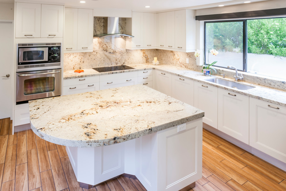 Example of a mid-sized transitional l-shaped ceramic tile enclosed kitchen design in San Francisco with a single-bowl sink, shaker cabinets, white cabinets, granite countertops, multicolored backsplash, stone slab backsplash, stainless steel appliances and an island