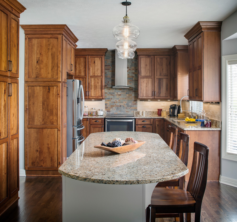 Kitchen - rustic u-shaped dark wood floor and brown floor kitchen idea in Omaha with an undermount sink, shaker cabinets, dark wood cabinets, beige backsplash, stainless steel appliances, an island and beige countertops
