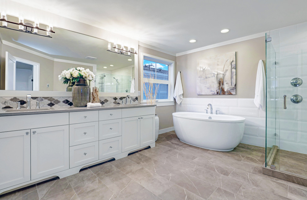 Design ideas for a transitional master bathroom in Seattle with shaker cabinets, white cabinets, a freestanding tub, gray tile, grey walls, an undermount sink, grey floor, grey benchtops, a corner shower, porcelain tile, porcelain floors, a hinged shower door and a double vanity.