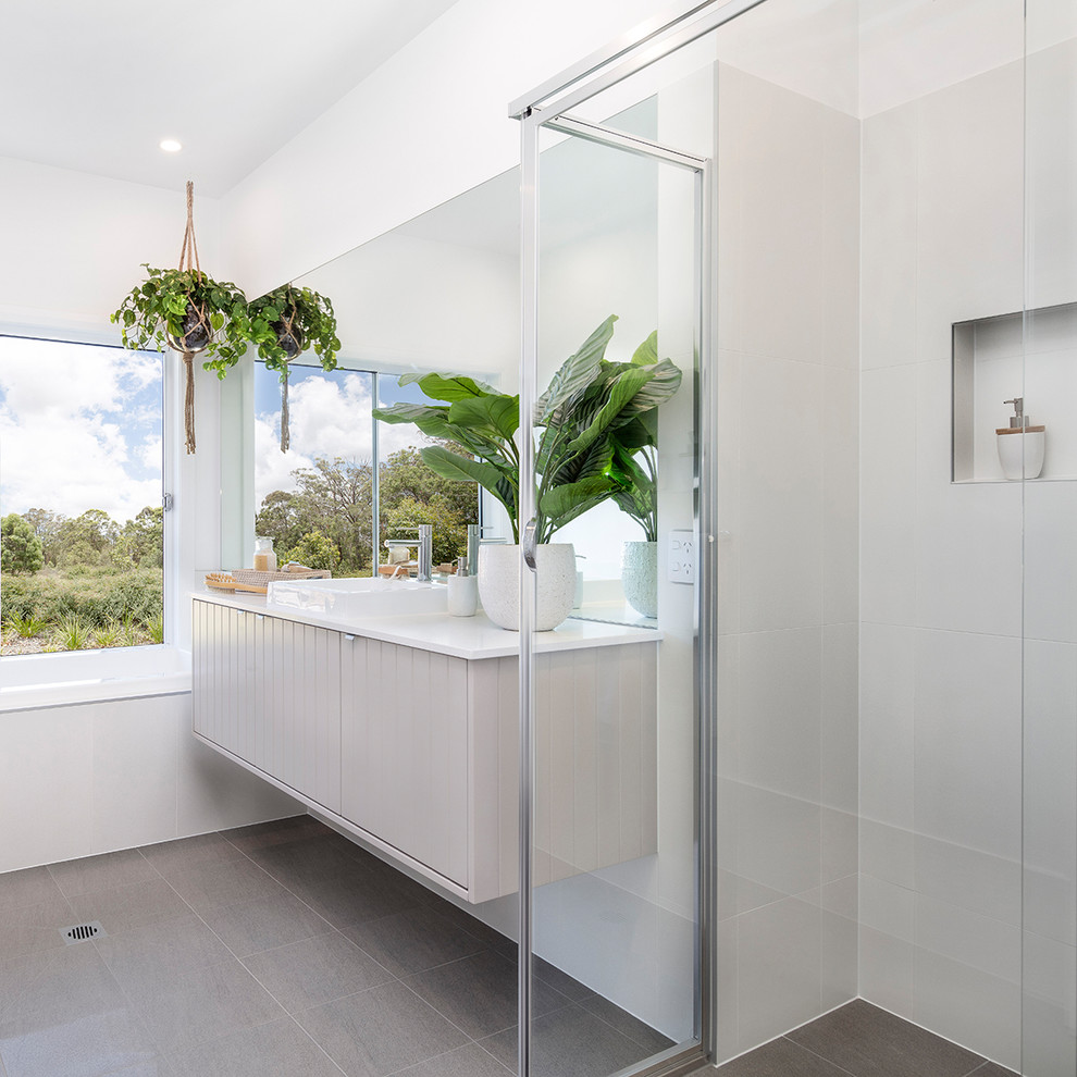 Large beach style master bathroom in Sydney with shaker cabinets, white cabinets, a corner shower, white tile, ceramic tile, white walls, cement tiles, an undermount sink, marble benchtops, green floor, a hinged shower door and white benchtops.