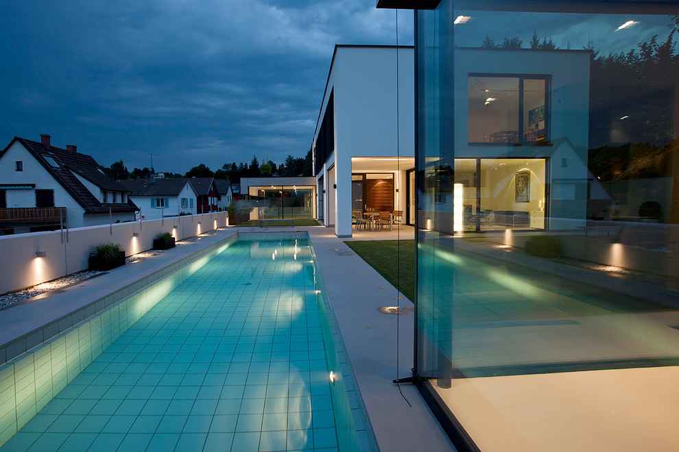 Großer, Gefliester Moderner Pool neben dem Haus in rechteckiger Form in Stuttgart