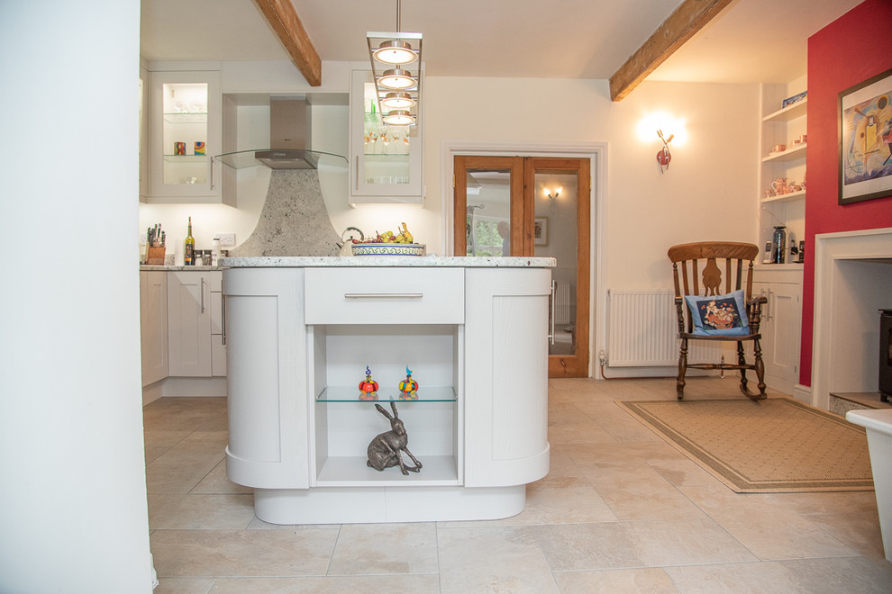 Mid-sized traditional kitchen in Sussex with a drop-in sink, shaker cabinets, grey cabinets, granite benchtops, grey splashback, black appliances, with island and grey benchtop.