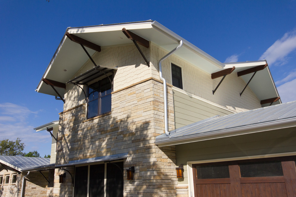Photo of a large eclectic two-storey beige house exterior in Austin with mixed siding, a gable roof and a metal roof.