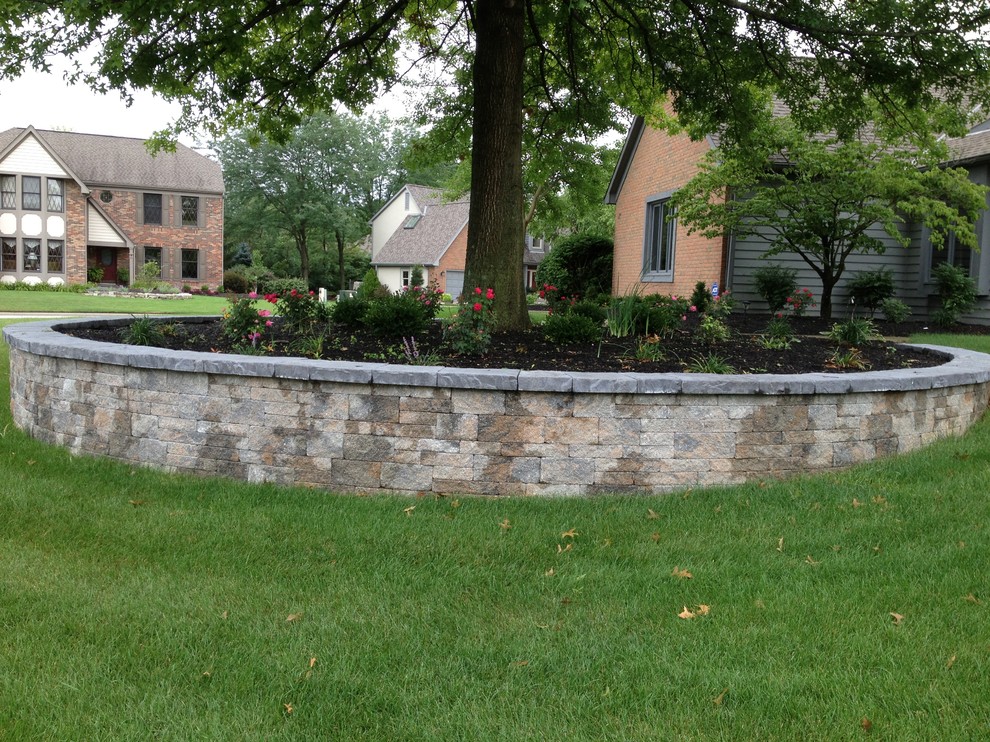 This is an example of a mid-sized traditional front yard shaded garden for summer in Columbus with a retaining wall and concrete pavers.