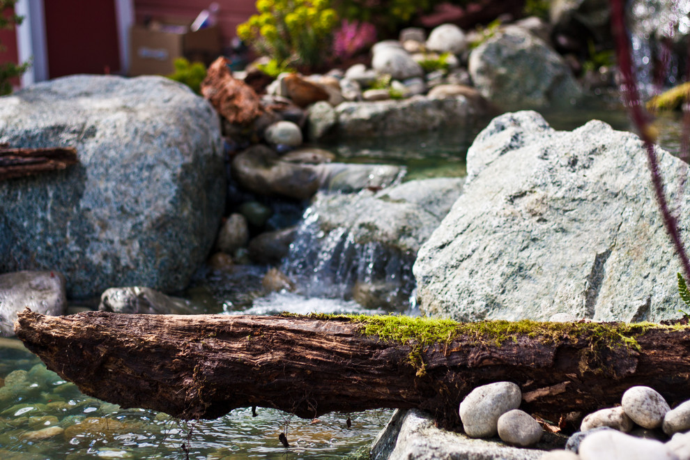 This is an example of a mid-sized rustic partial sun backyard stone formal garden in Seattle for spring.