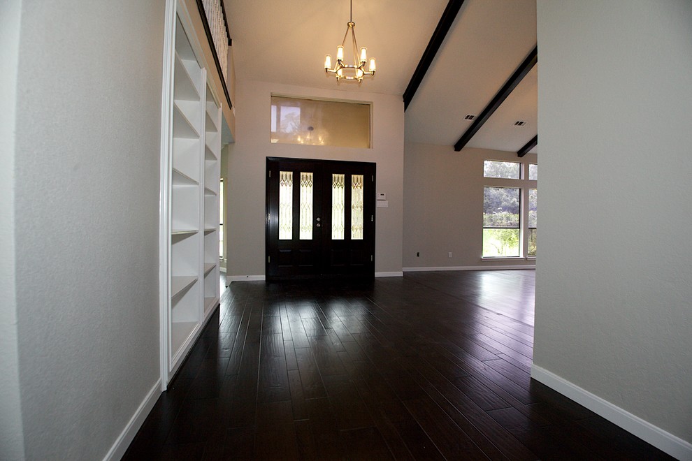 Photo of a large transitional front door in Houston with grey walls, dark hardwood floors, a double front door and a glass front door.