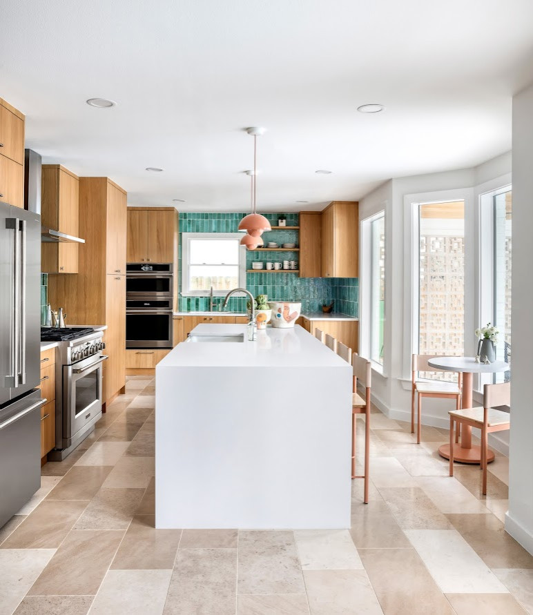 Photo of a small modern l-shaped kitchen/diner in Austin with an island, a built-in sink, flat-panel cabinets, medium wood cabinets, glass worktops, blue splashback, ceramic splashback, integrated appliances, light hardwood flooring, brown floors, white worktops and a drop ceiling.
