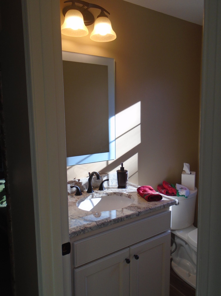 Inspiration for a small transitional powder room in Baltimore with white cabinets and granite benchtops.