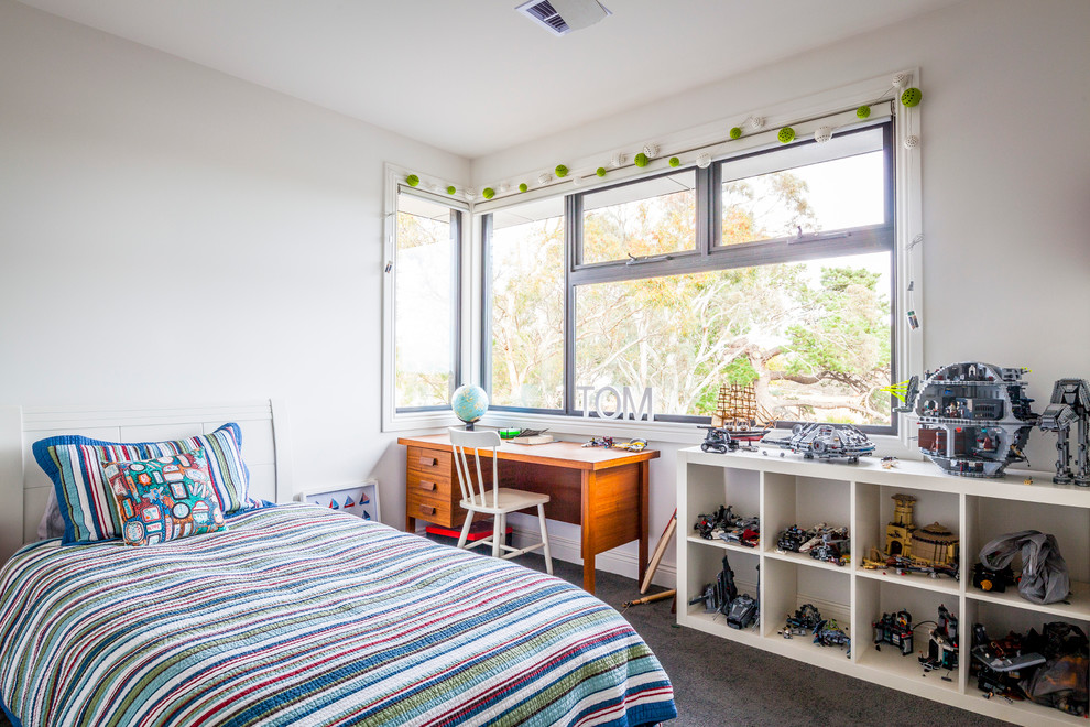 This is an example of a mid-sized contemporary kids' bedroom for boys in Melbourne with white walls and carpet.