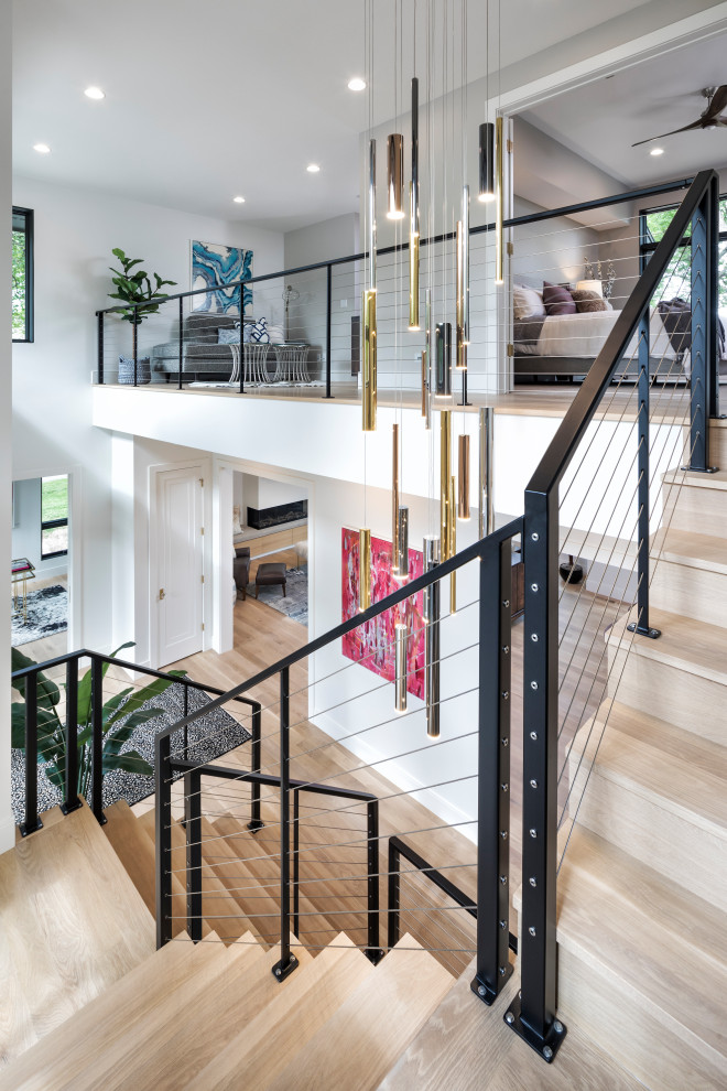 This is an example of a large contemporary wood l-shaped staircase in Minneapolis with wood risers and metal railing.
