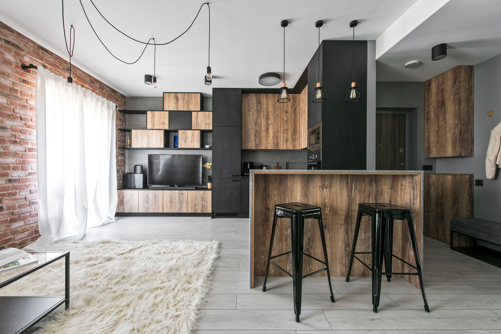 This is an example of a mid-sized contemporary open plan kitchen in Lyon with flat-panel cabinets, black cabinets, grey splashback and a peninsula.