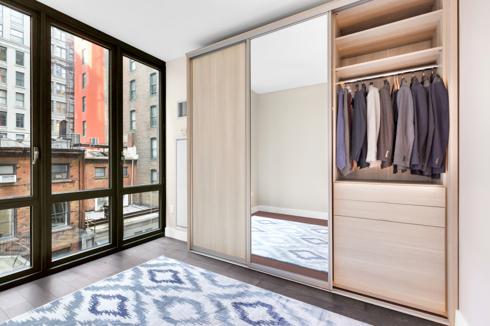 Inspiration for a large modern gender-neutral storage and wardrobe in New York with flat-panel cabinets, brown cabinets and dark hardwood floors.