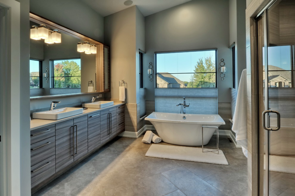 Large midcentury master bathroom in Omaha with flat-panel cabinets, grey cabinets, a freestanding tub, an alcove shower, porcelain tile, blue walls, porcelain floors, a drop-in sink, solid surface benchtops, grey floor, a hinged shower door, beige benchtops and beige tile.