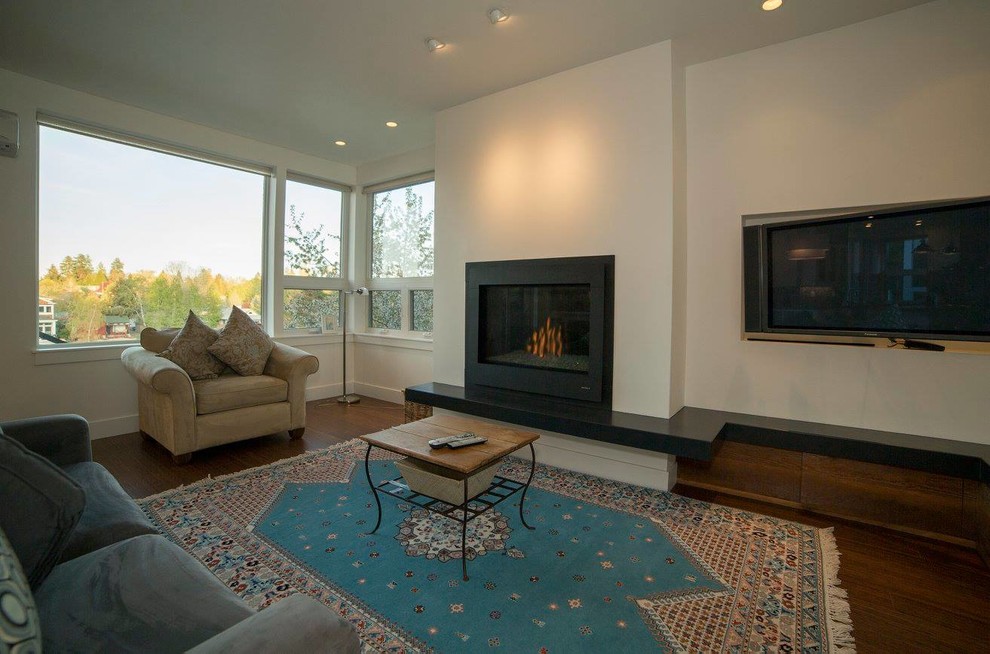 Mid-sized contemporary enclosed living room in Other with white walls, dark hardwood floors, a standard fireplace, a metal fireplace surround and a wall-mounted tv.