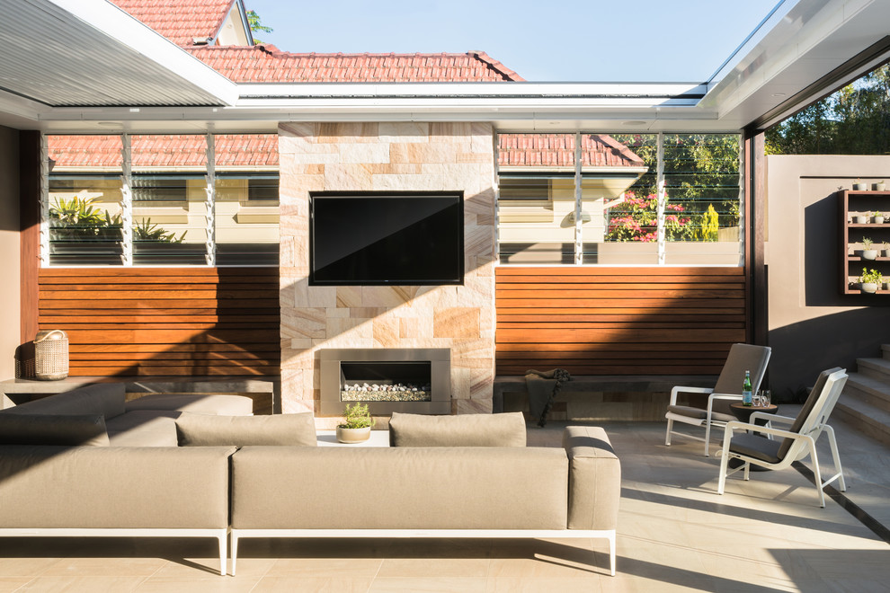 This is an example of a contemporary backyard patio in Sydney with with fireplace and a pergola.