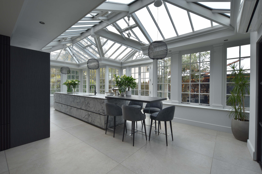 Large contemporary galley open plan kitchen in Manchester with flat-panel cabinets, granite worktops, porcelain flooring, an island, grey worktops and grey floors.