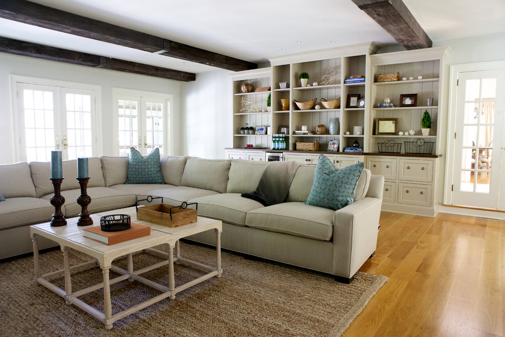 This is an example of a transitional family room in Boston with white walls and medium hardwood floors.