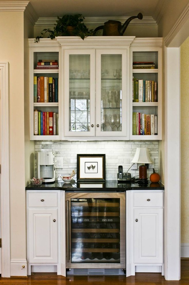 This is an example of a traditional eat-in kitchen in Nashville with raised-panel cabinets, white cabinets, granite benchtops, grey splashback and stainless steel appliances.