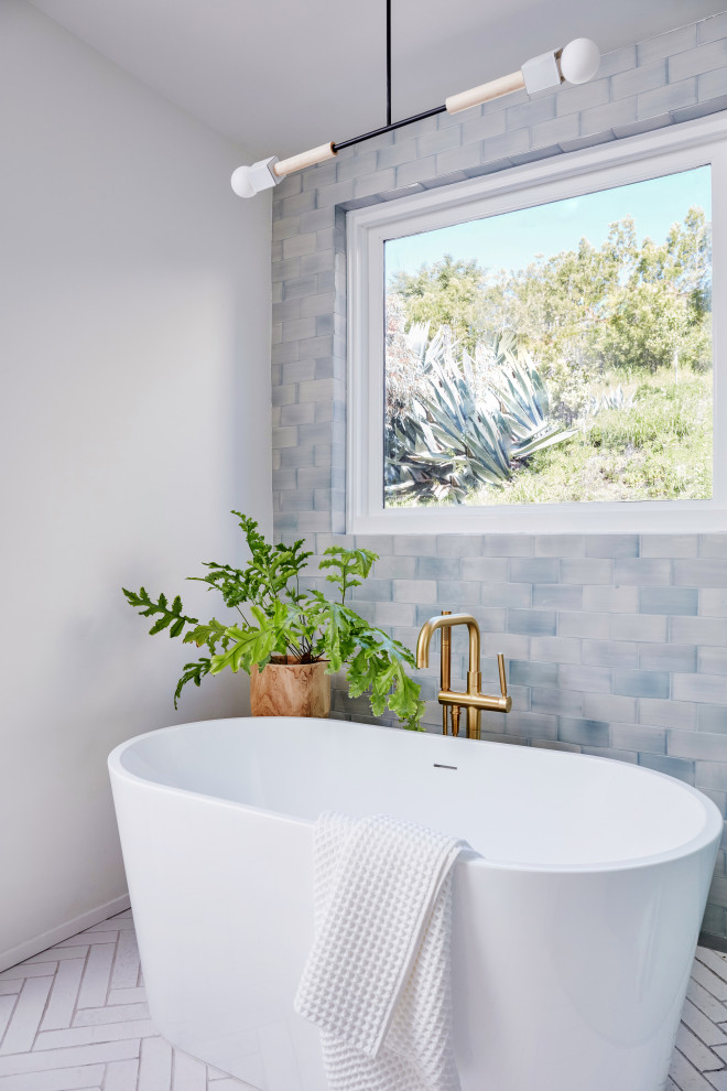 Inspiration for a medium sized modern ensuite bathroom in Los Angeles with flat-panel cabinets, light wood cabinets, a freestanding bath, a corner shower, blue tiles, ceramic tiles, white walls, brick flooring, marble worktops, white floors, white worktops, an enclosed toilet, double sinks and a built in vanity unit.