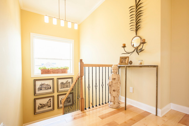 Inspiration for a mid-sized traditional hallway in Louisville with beige walls and light hardwood floors.
