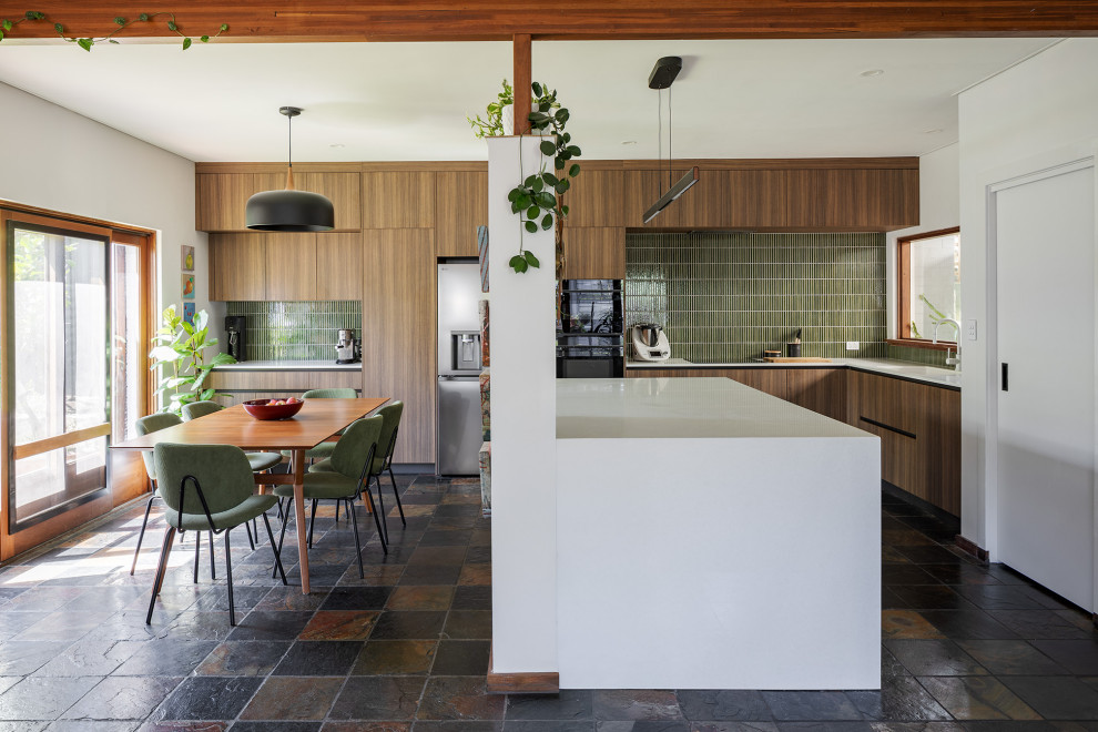 Photo of a mid-sized midcentury kitchen in Perth with an undermount sink, medium wood cabinets, green splashback, slate floors, with island and white benchtop.