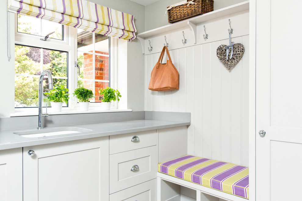 Inspiration for a transitional single-wall laundry room in Berkshire with an undermount sink, shaker cabinets, white cabinets, grey walls and grey benchtop.